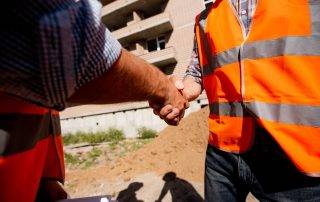 Happy colorado springs homeowner shaking hands with excavation contractor