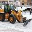 Commercial snow plow clearing large parking lot in Colorado Springs