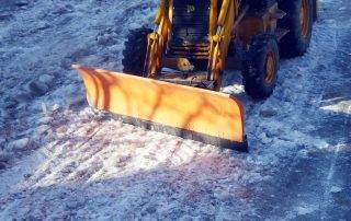 Snow plow clearing parking lot at Colorado Springs retail center