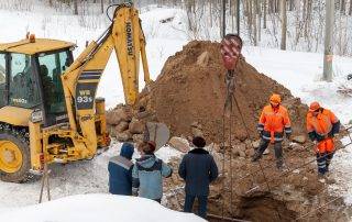 Emergency excavation crew working on a frozen commercial site in Colorado Springs during winter
