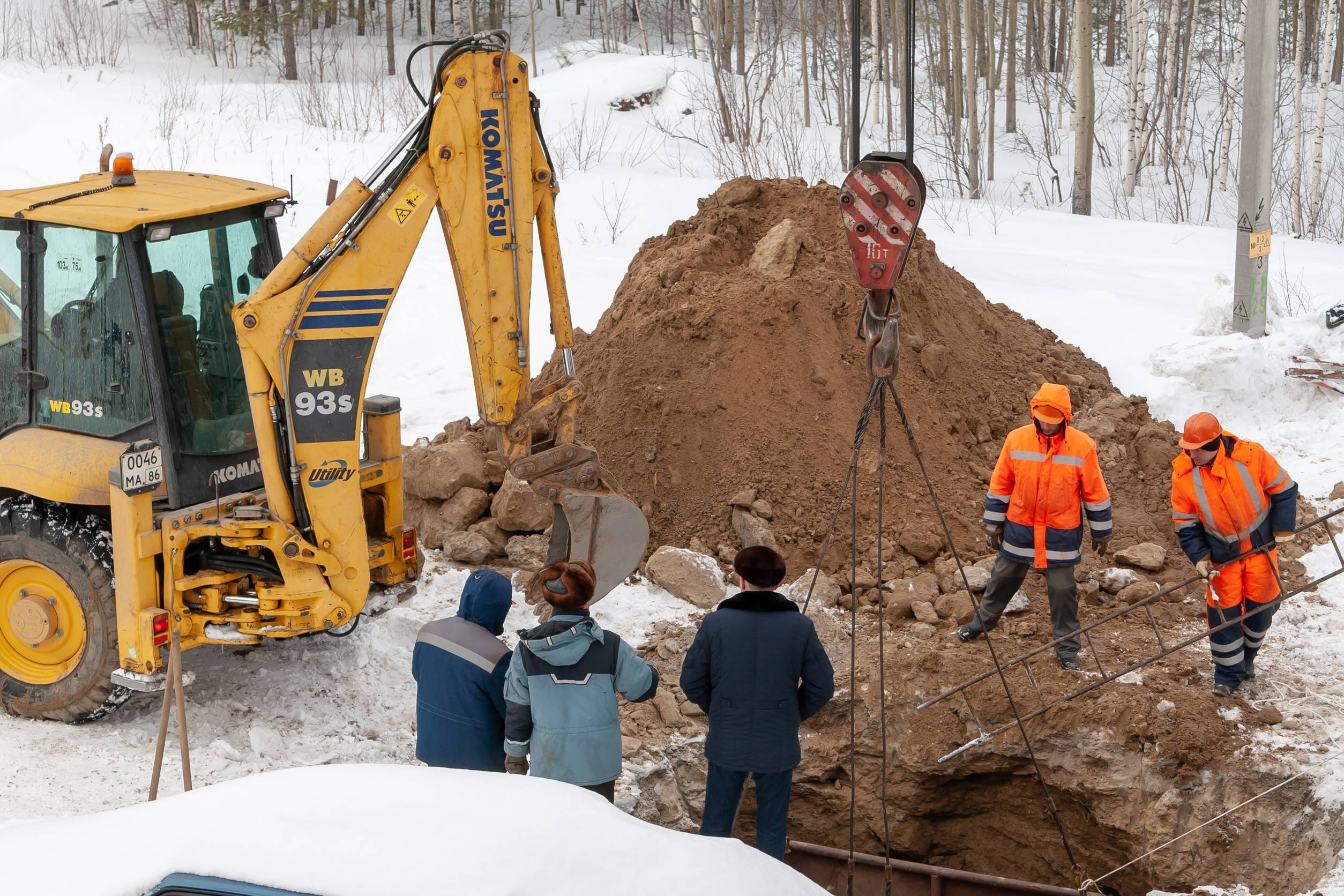 Emergency excavation crew working on a frozen commercial site in Colorado Springs during winter