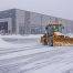Plow truck and skid steer clearing snow in a large Colorado Springs commercial parking lot